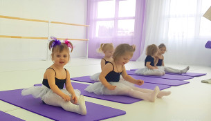 Балет в Сочи: малышки двух лет в балетных пачках сидят на ковриках в танцевальном зале.